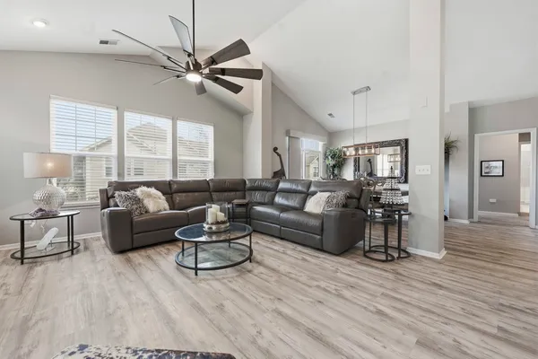 a living room with furniture a flat screen tv and a large window