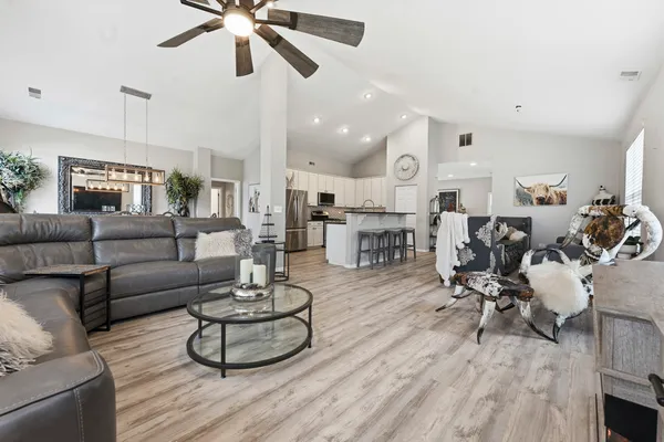a kitchen with stainless steel appliances granite countertop a table chairs sink and cabinets