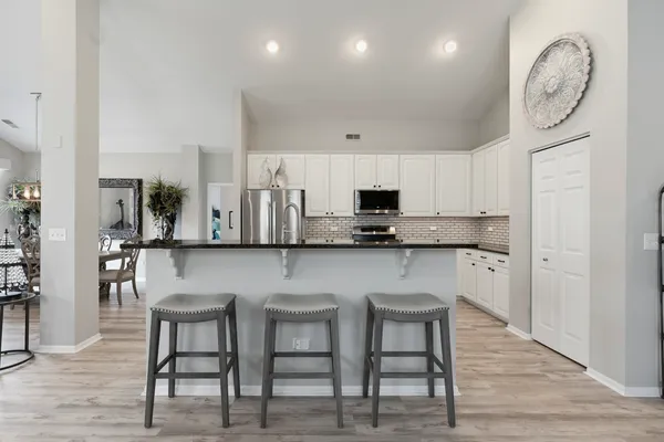 a kitchen with granite countertop white cabinets and stainless steel appliances