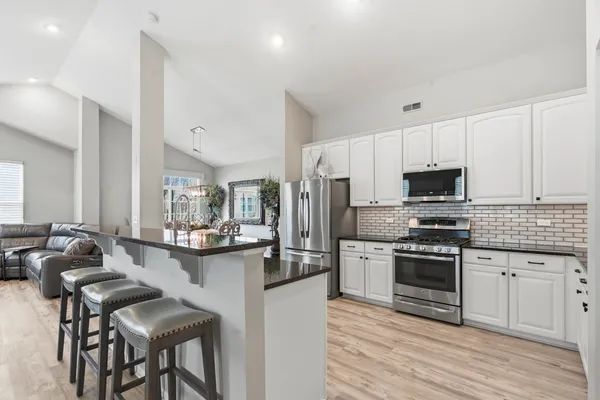 a kitchen with stainless steel appliances granite countertop a stove and a refrigerator