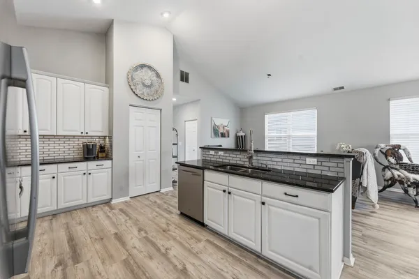 a kitchen with stainless steel appliances a refrigerator sink and cabinets