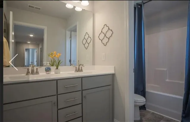 a bathroom with a double vanity sink and a mirror