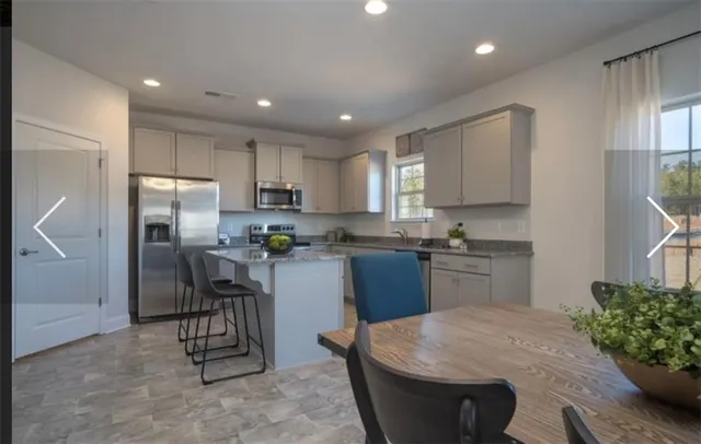 a kitchen with refrigerator a sink and chairs