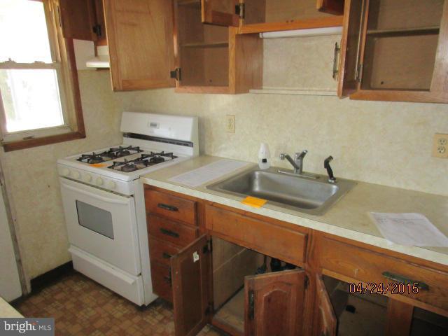 1909 Barry Road Baltimore, MD 21222 - Photo 4 of 12 a kitchen with a sink stove and cabinets