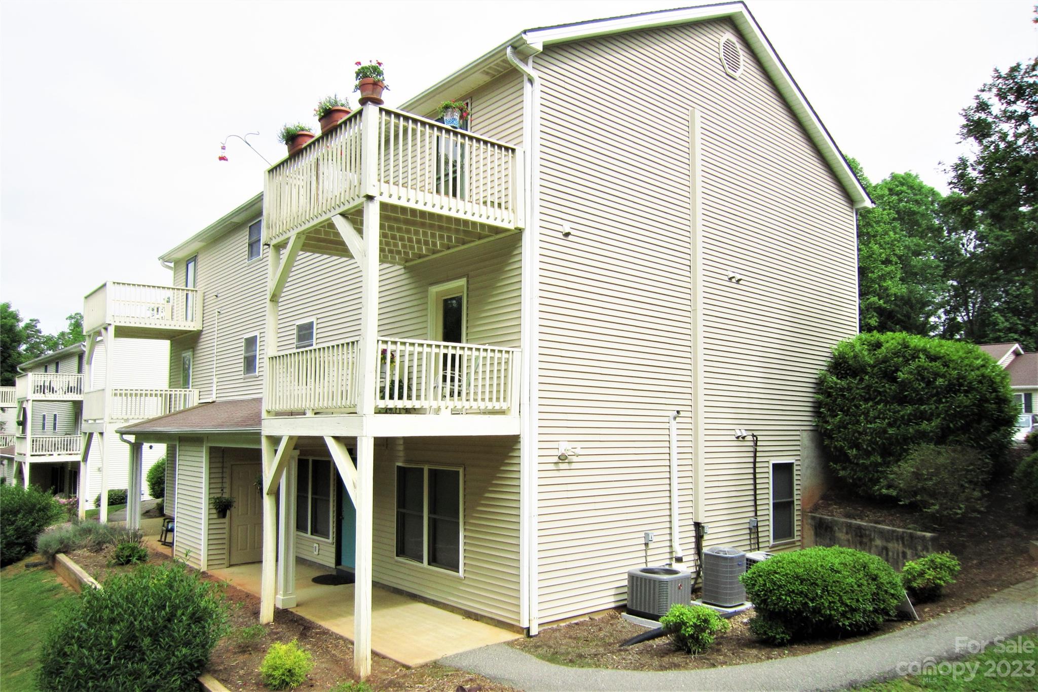 7 Krista Circle, Unit E Candler, NC 28715 - Photo 1 of 24 a view of white house with a small yard and potted plants