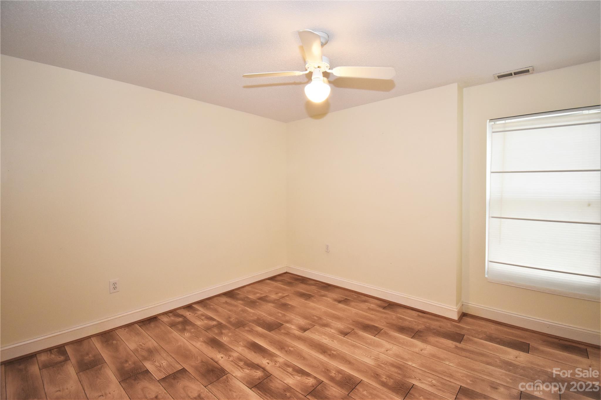 7 Krista Circle, Unit E Candler, NC 28715 - Photo 14 of 24 an empty room with a window and ceiling fan