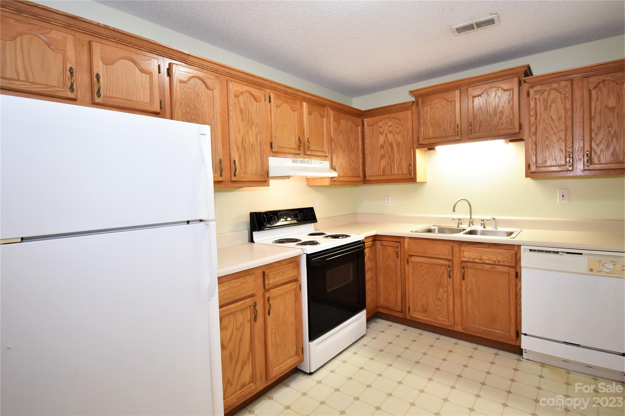 7 Krista Circle, Unit E Candler, NC 28715 - Photo 6 of 24 a kitchen with stainless steel appliances granite countertop a refrigerator sink and cabinets