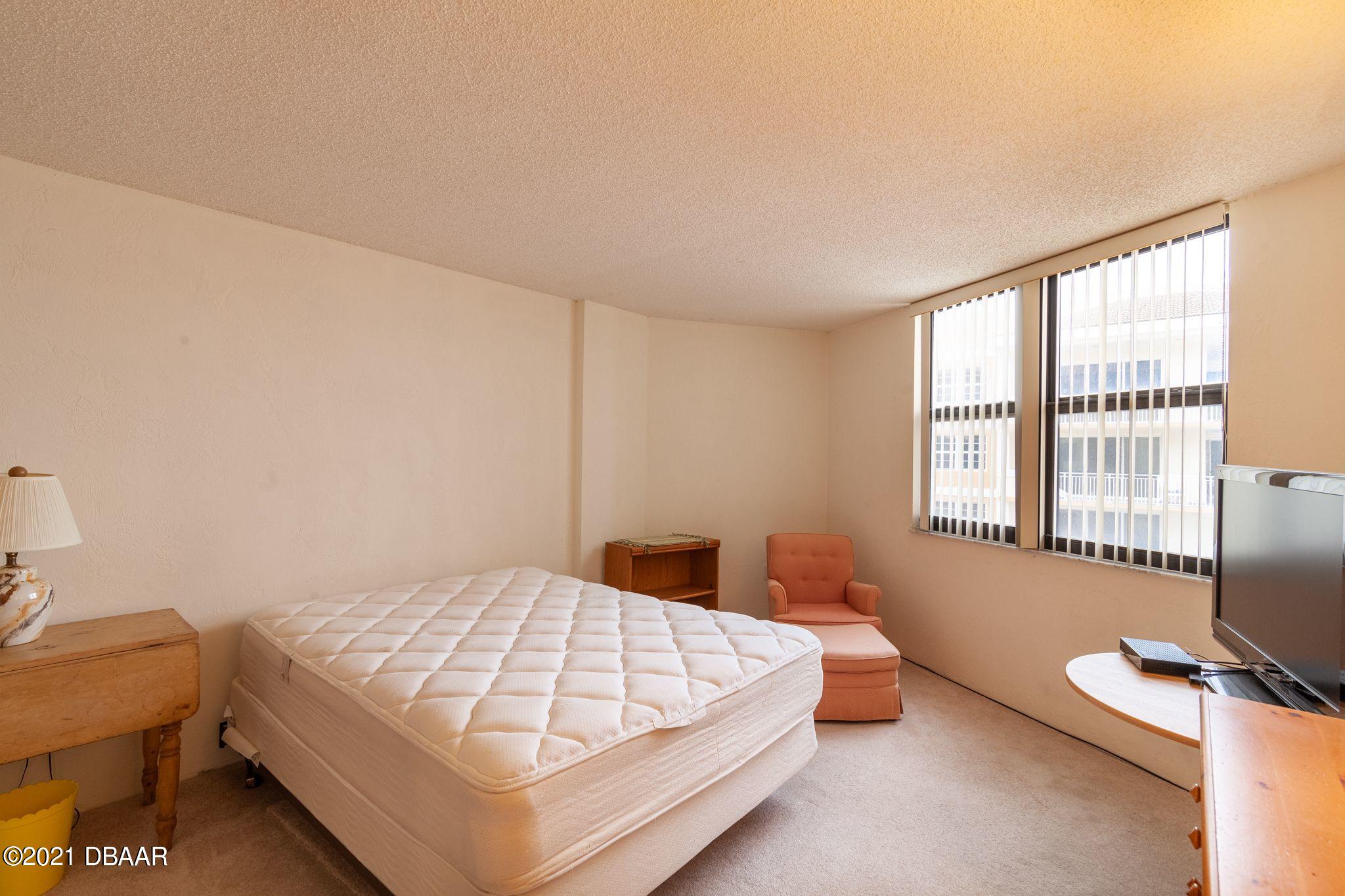 1415 Ocean Shore Boulevard, Unit 903 Ormond Beach, FL 32176 - Photo 18 of 47 a bedroom with a bed and wooden floor