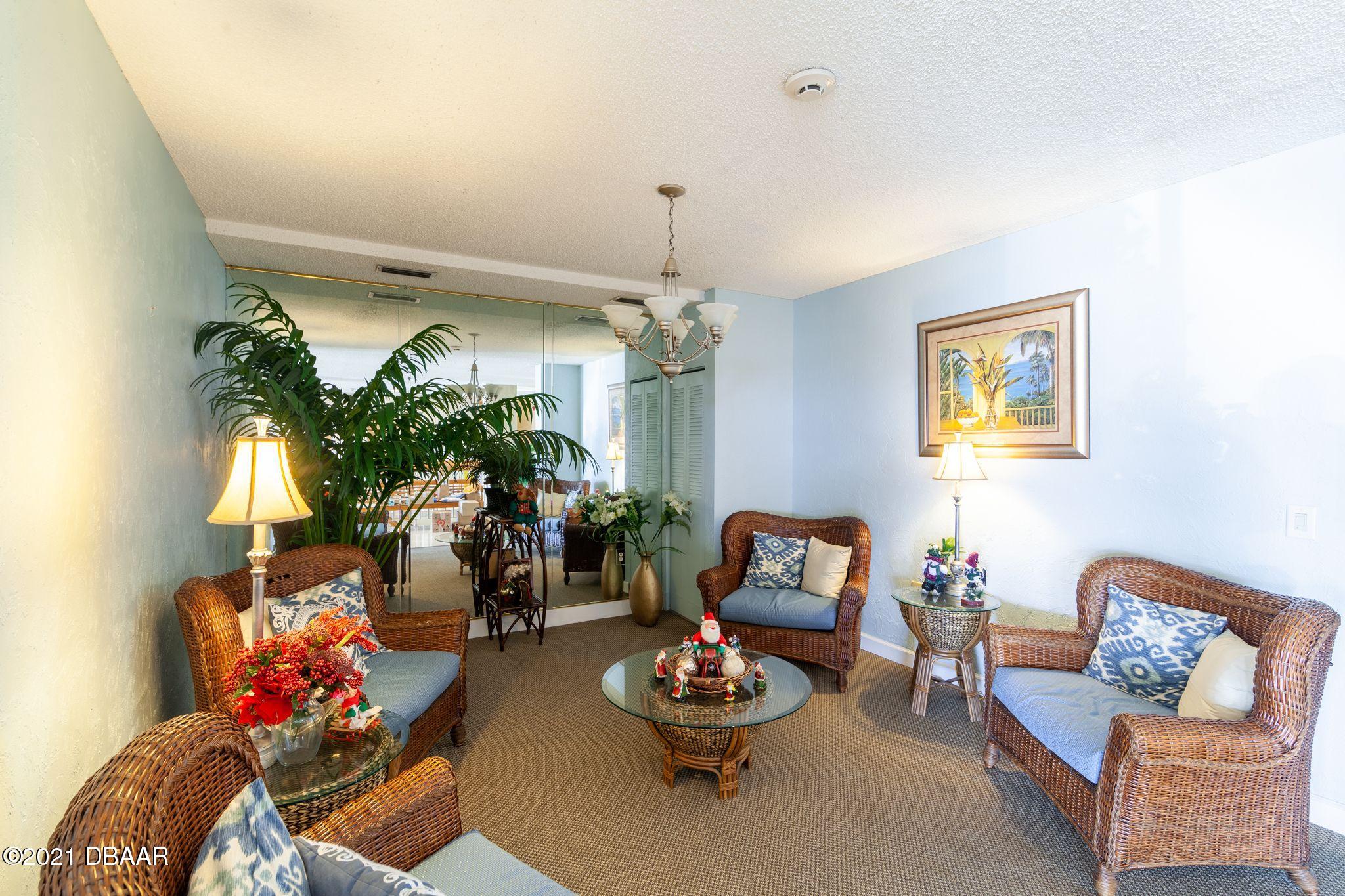 1415 Ocean Shore Boulevard, Unit 903 Ormond Beach, FL 32176 - Photo 34 of 47 a living room with furniture and a chandelier