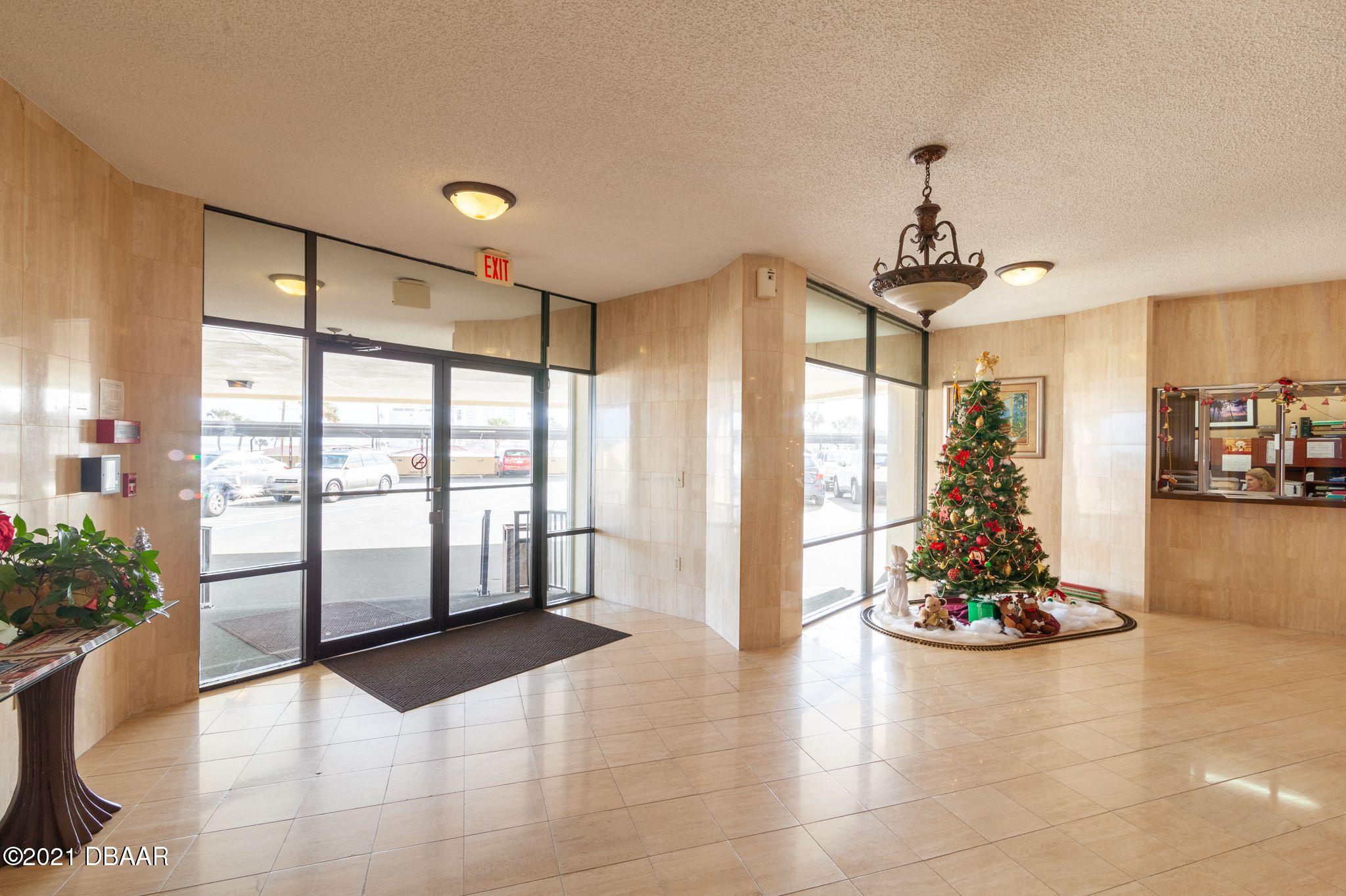 1415 Ocean Shore Boulevard, Unit 903 Ormond Beach, FL 32176 - Photo 35 of 47 a hallway with a chandelier and living room