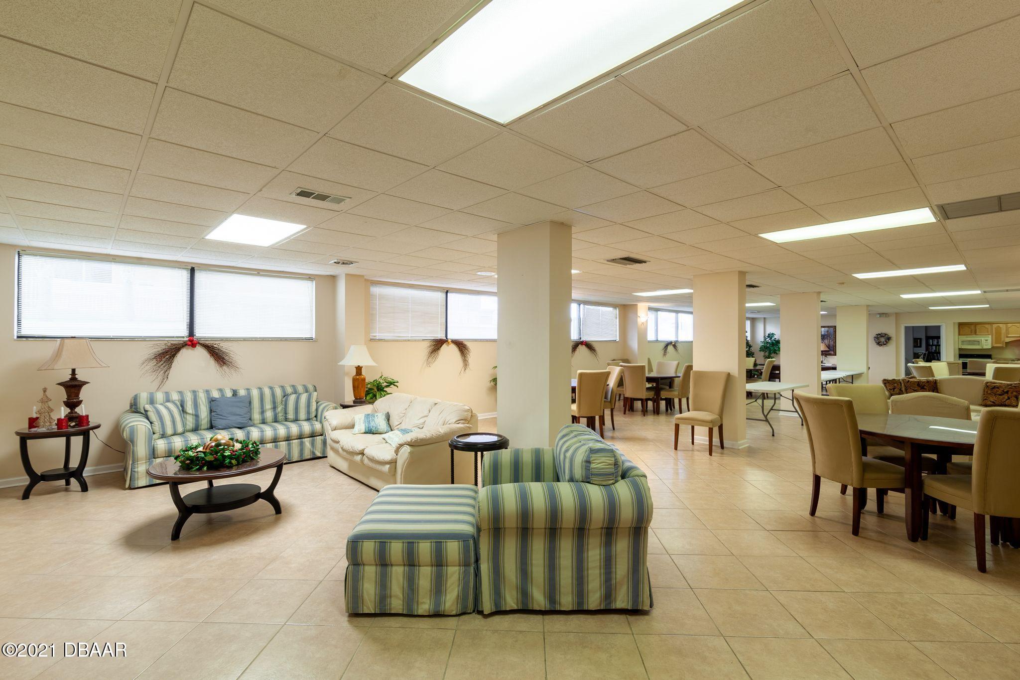 1415 Ocean Shore Boulevard, Unit 903 Ormond Beach, FL 32176 - Photo 37 of 47 a living room with furniture and a table