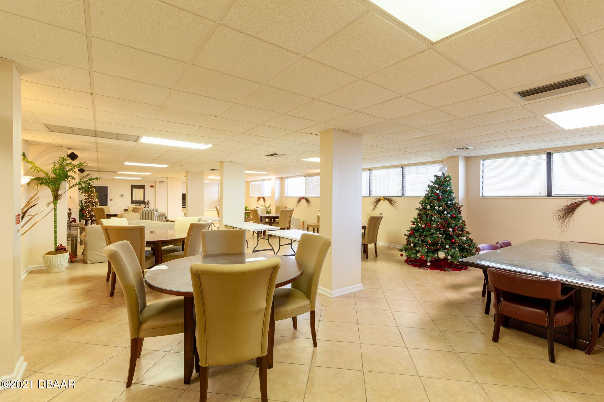 1415 Ocean Shore Boulevard, Unit 903 Ormond Beach, FL 32176 - Photo 38 of 47 a dining room with furniture and a potted plant