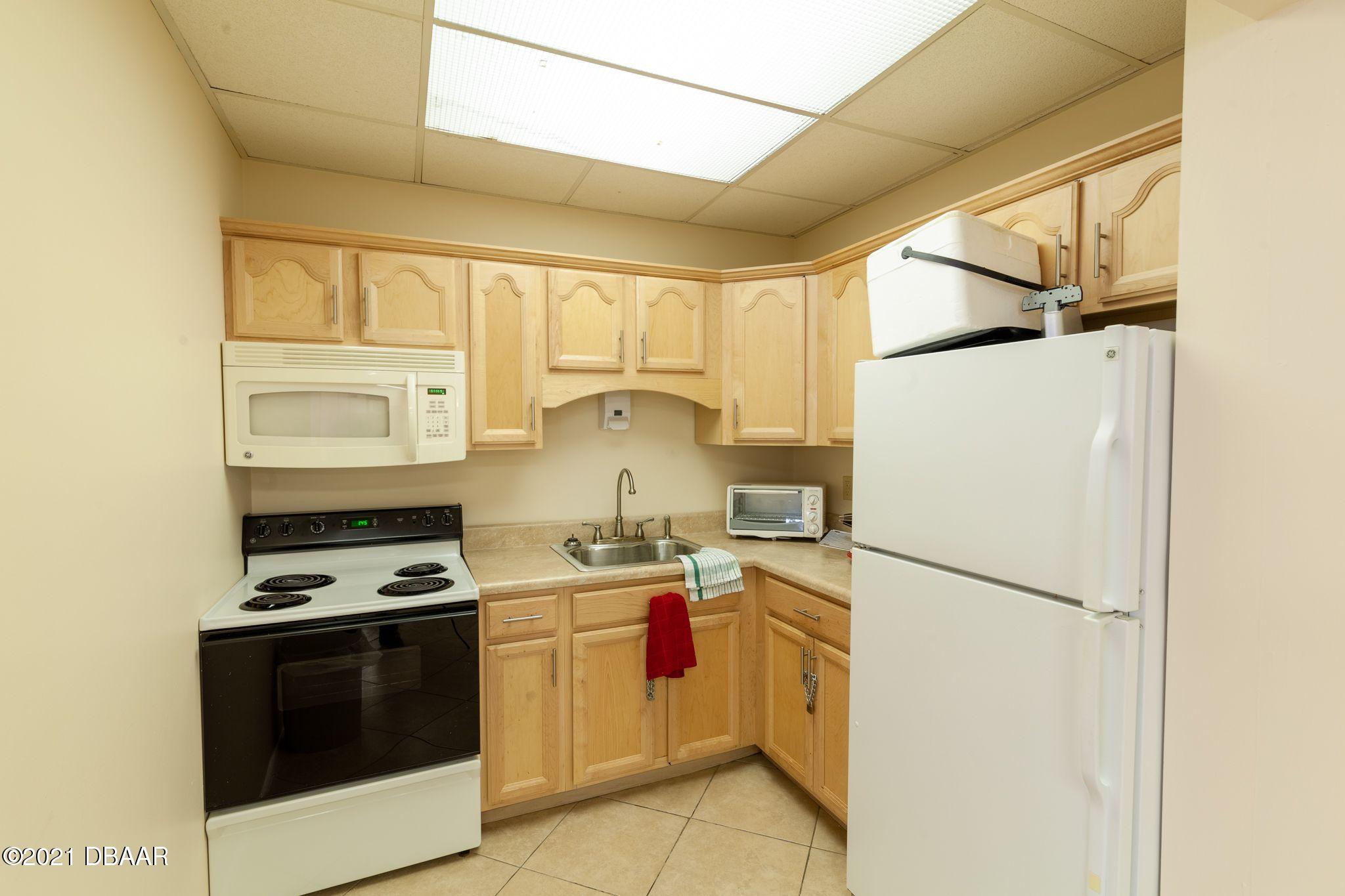 1415 Ocean Shore Boulevard, Unit 903 Ormond Beach, FL 32176 - Photo 39 of 47 a kitchen with stainless steel appliances a stove a sink and a refrigerator