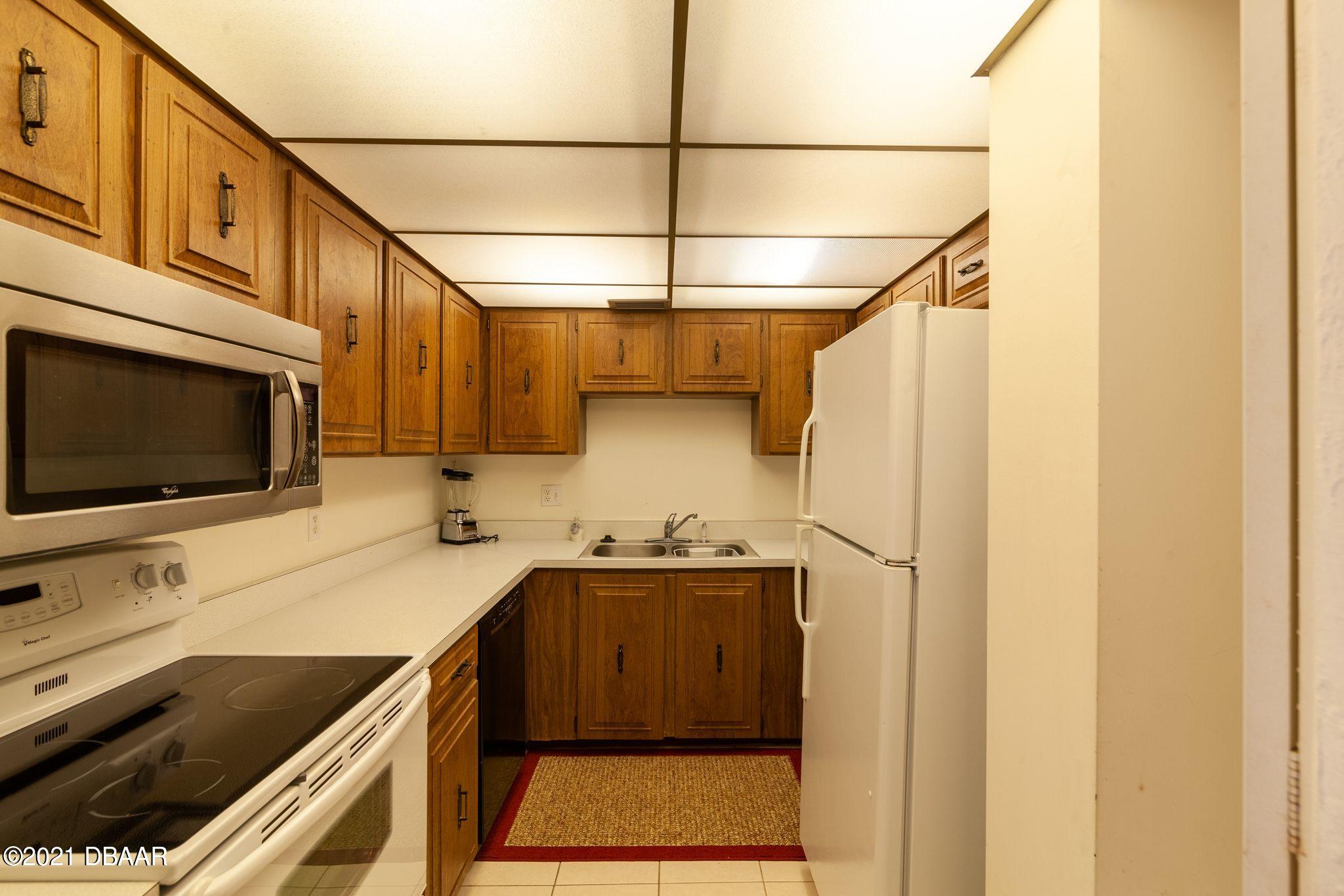 1415 Ocean Shore Boulevard, Unit 903 Ormond Beach, FL 32176 - Photo 8 of 47 a kitchen that has a sink and a stove in it