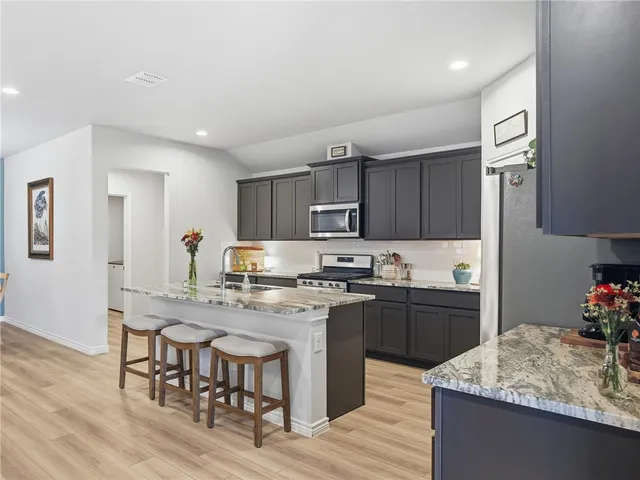a kitchen with kitchen island granite countertop a sink and stove
