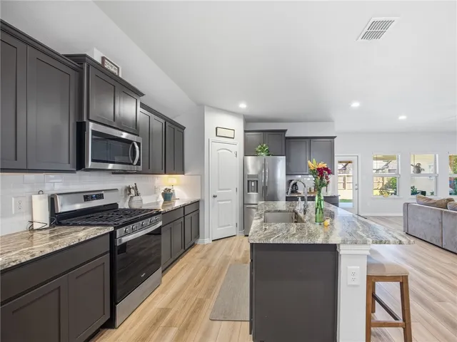a kitchen with stainless steel appliances a sink stove and refrigerator