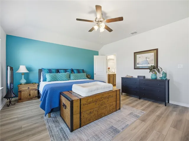 a bedroom with a large bed and a chandelier