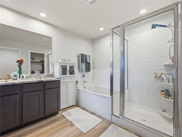a bathroom with a tub sink shower and mirror