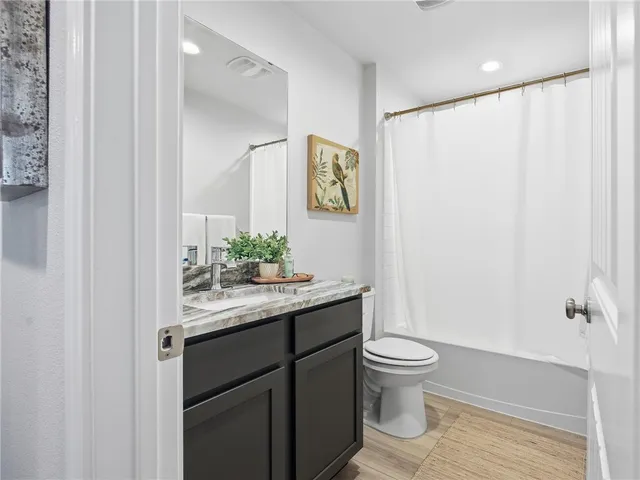 a bathroom with a granite countertop sink a toilet and a mirror