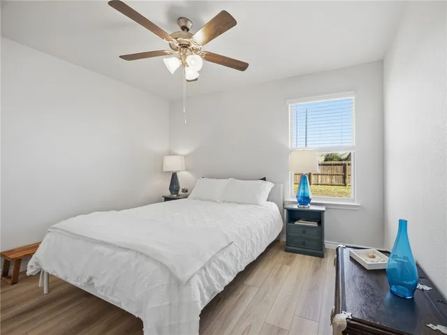 a bedroom with a bed window and a chair