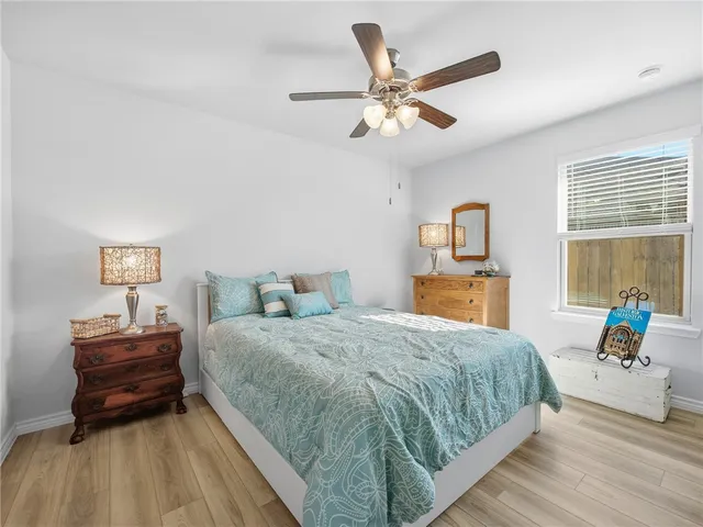 a kitchen with a stove a refrigerator and a dining table with wooden floor