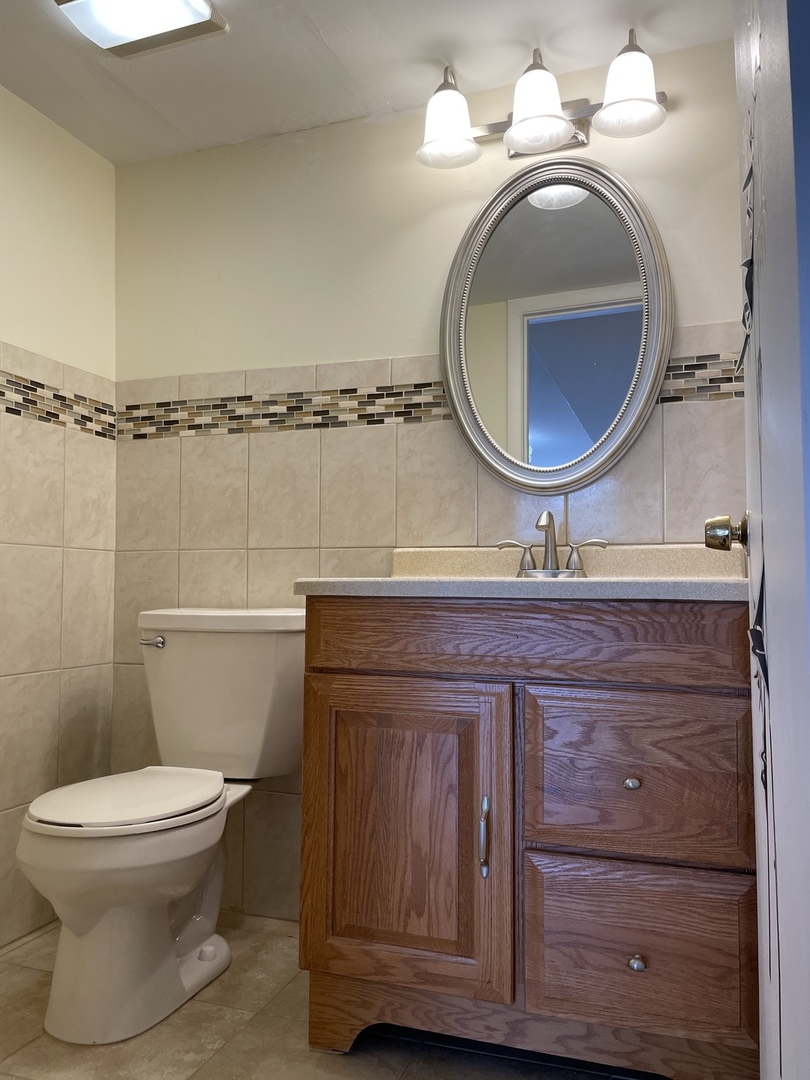 9137 Barberry Lane, Unit 9137 Des Plaines, IL 60016 - Photo 18 of 22 a bathroom with a toilet a sink and mirror