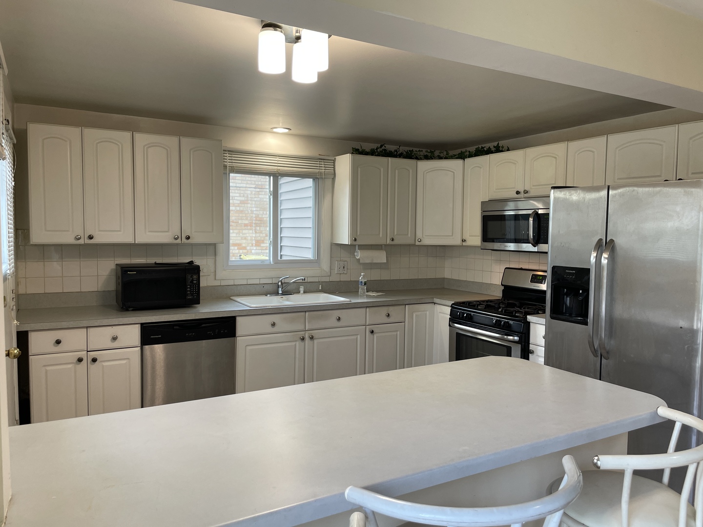 9137 Barberry Lane, Unit 9137 Des Plaines, IL 60016 - Photo 8 of 22 a kitchen with granite countertop a refrigerator stove microwave and sink