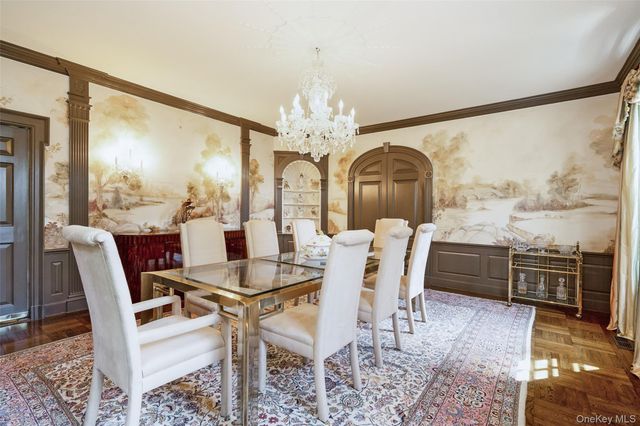 a dining room with furniture a chandelier and wooden floor
