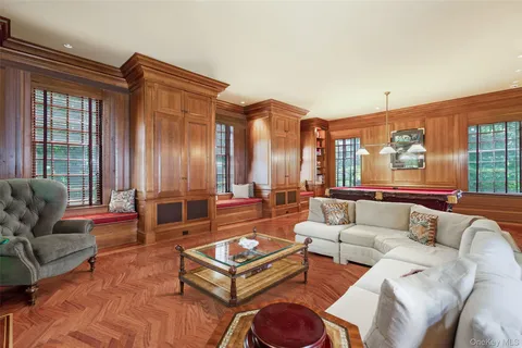 a living room with furniture a large window and a chandelier