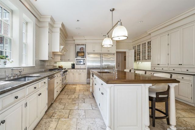 a large kitchen with granite countertop a sink stove and cabinets