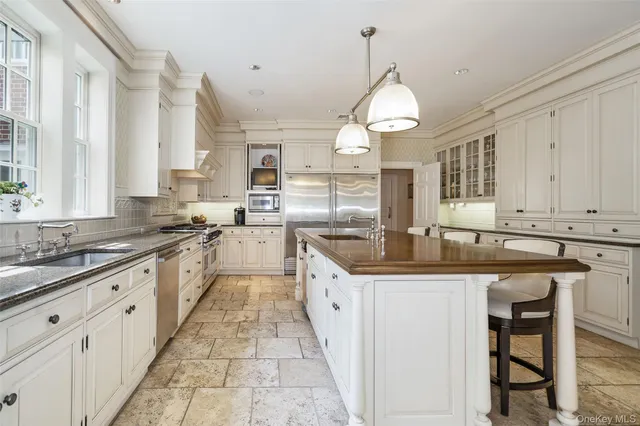 a large kitchen with granite countertop a sink stove and cabinets