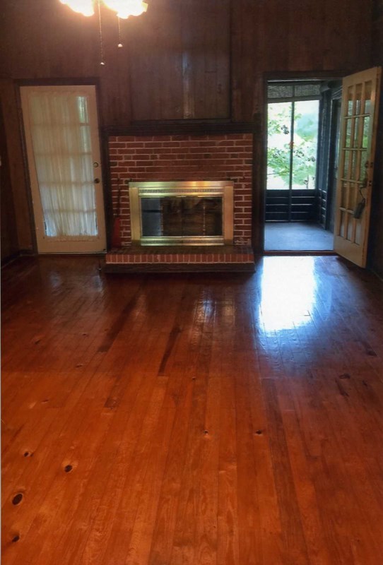 6829 Lower Thomaston Road Macon, GA 31220 - Photo 6 of 11 an empty room with wooden floor fire place and windows