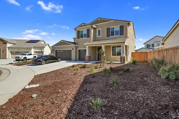 a kitchen with stainless steel appliances kitchen island granite countertop a dining table chairs and a refrigerator