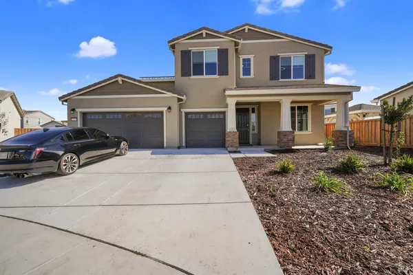 a kitchen with stainless steel appliances granite countertop a stove a refrigerator a kitchen island a dining table and chairs with wooden floor