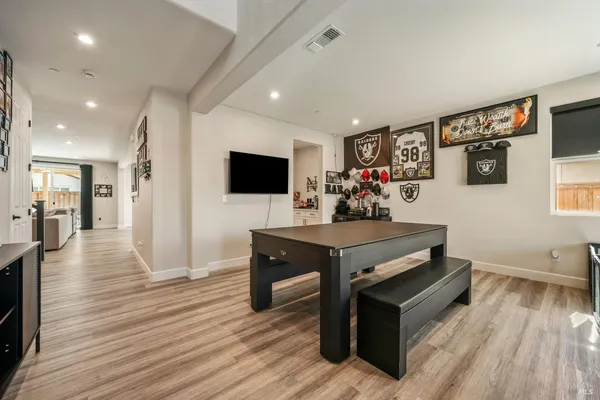 a kitchen with stainless steel appliances a stove top oven a sink dishwasher and a refrigerator with wooden floor