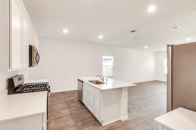 a kitchen with stainless steel appliances granite countertop a sink stove and refrigerator