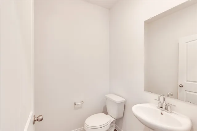 a bathroom with a sink a toilet and mirror