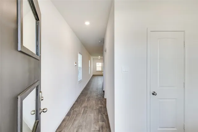 a view of a hallway with wooden floor and staircase