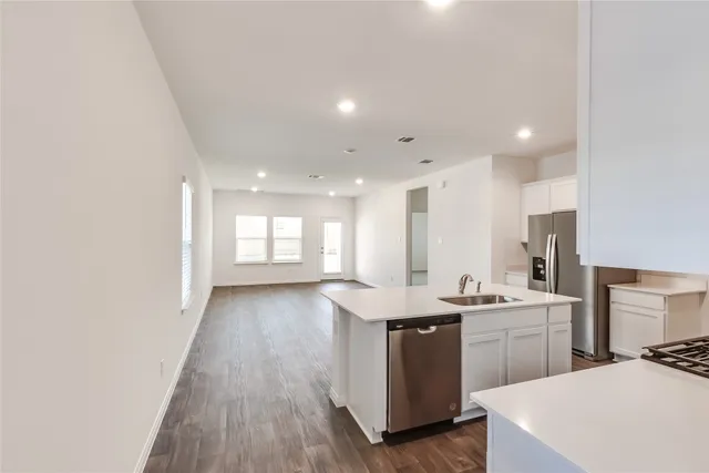 a kitchen with a sink a window stainless steel appliances and cabinets