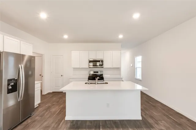 a kitchen with kitchen island a sink stainless steel appliances and cabinets
