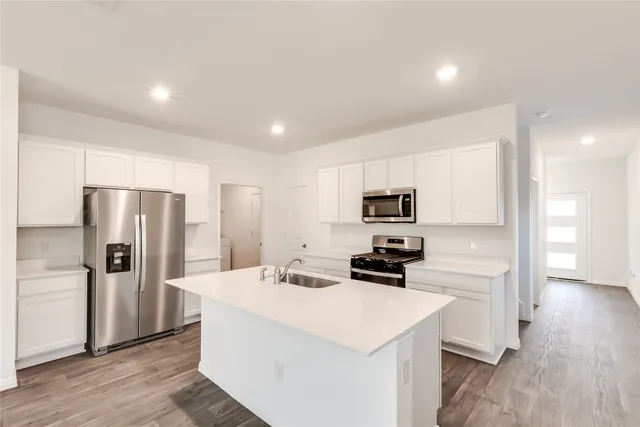 a kitchen with stainless steel appliances a refrigerator stove microwave and sink