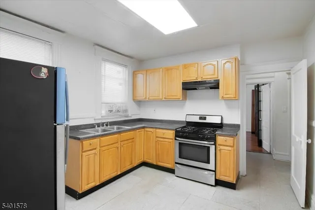 a kitchen with granite countertop white cabinets and black appliances