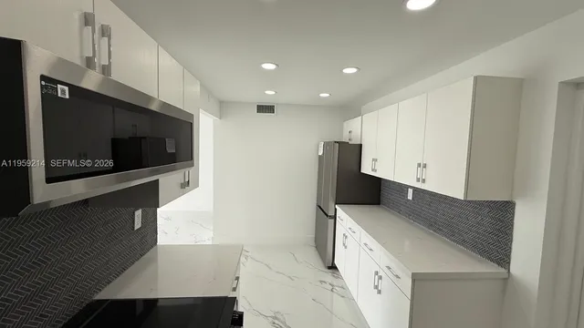 a kitchen with stainless steel appliances a stove microwave and sink