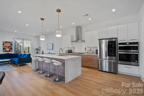 a large kitchen with kitchen island a large counter top stainless steel appliances and cabinets