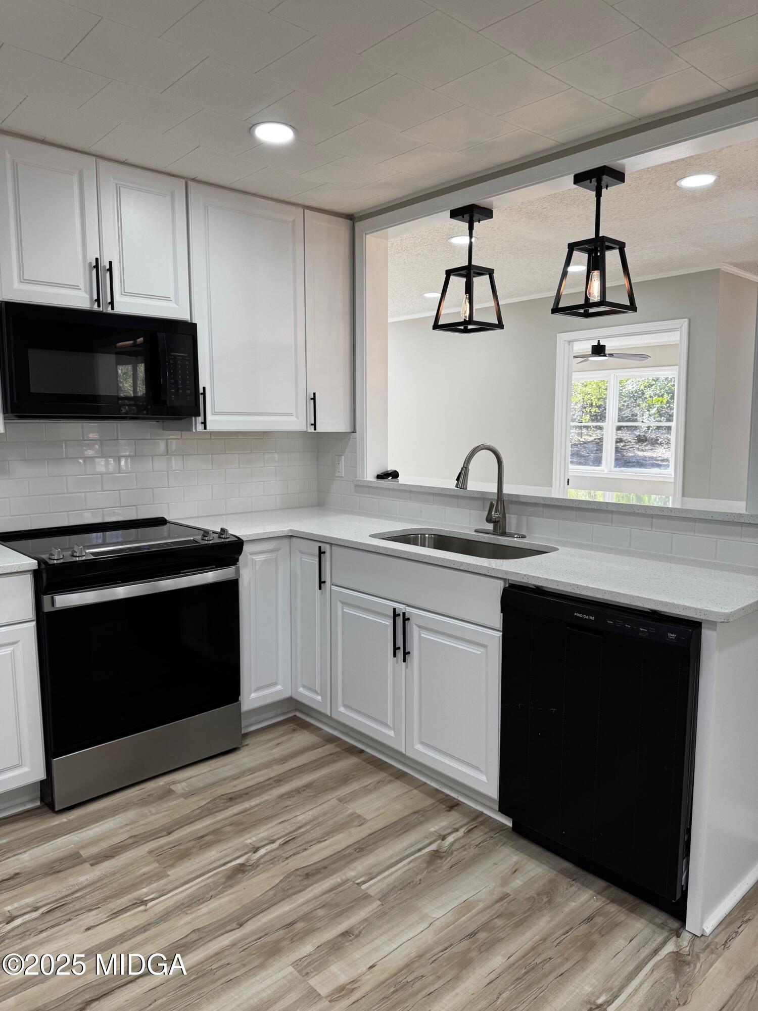 4105 Holley Road Lizella, GA 31052 - Photo 31 of 78 a kitchen with stainless steel appliances granite countertop a stove a sink and a microwave