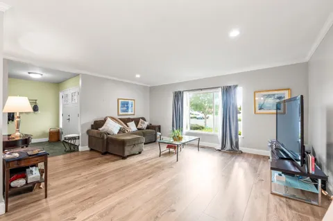 a view of a hallway with wooden floor and a bathroom