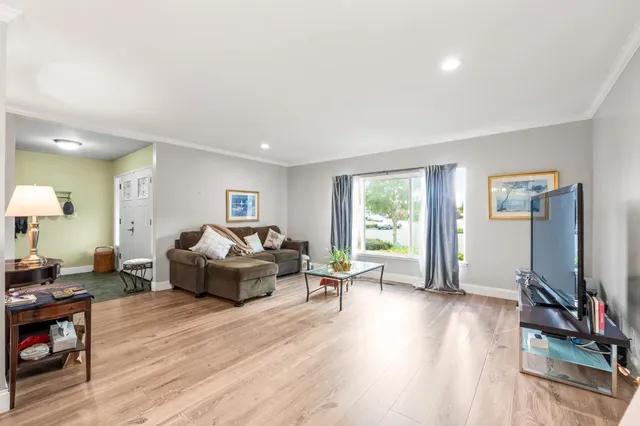 a view of a hallway with wooden floor and a bathroom