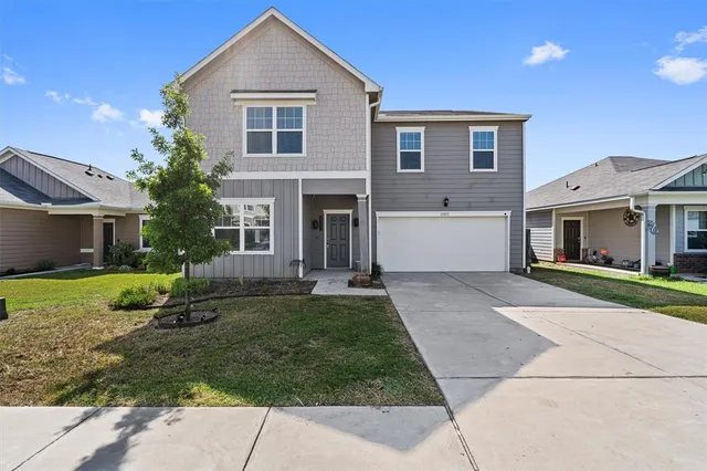 a front view of a house with a yard and garage