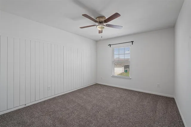 an empty room with chandelier fan
