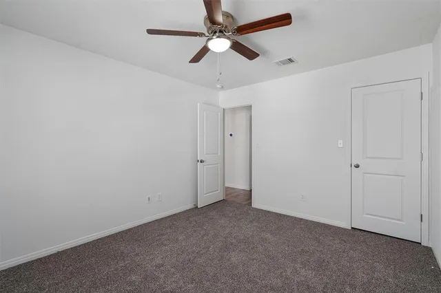 a view of a livingroom with a ceiling fan & window